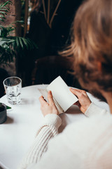 man reading a notebook with glass of water