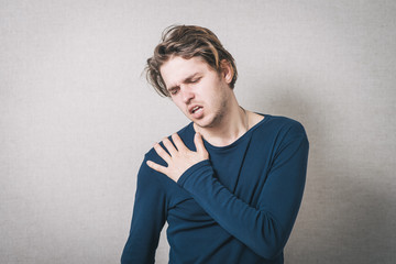 Man sore shoulder. Gray background