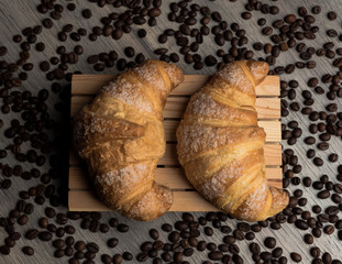 Colazione cornetti con un background grigio serviti su un piatto di legno