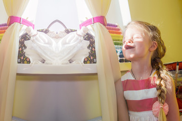 Portrait of a little girl at the window with her tongue hanging out teasingly