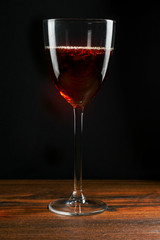  Glass of fortified wine on a wooden table, dark background.