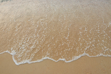 Fototapeta na wymiar Soft waves of the ocean on the sandy beach, summer beach, soft wave bubbles on the sandy beach
