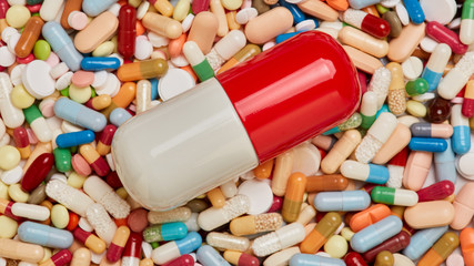 Colorful big capsule on small medication
