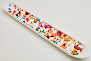 Bowl with a lot of colorful medicines drugs and tablets