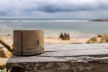 Fototapeta premium Ashtray made out of bamboo laying on a wooden table in front of the sea