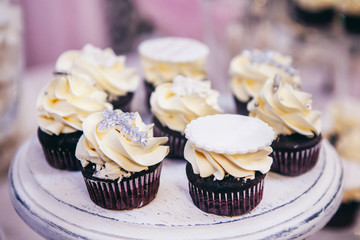 Cupcakes with cream and silver cross on top