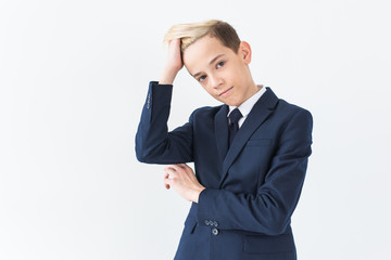 Portrait of stylish school boy teenager in white shirt and jacket against white background.
