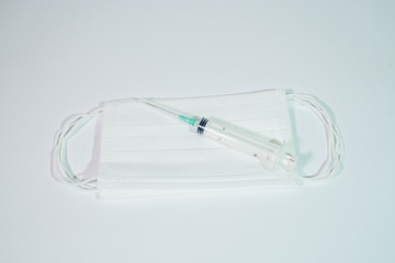 Syringe and white medical mask on a white background. Health care. Isolate