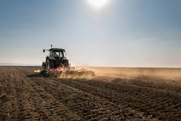 Crédence de cuisine en verre imprimé Tracteur Tractor is preparing the land at dusk
