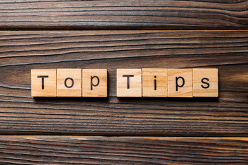 Top tips word written on wood block. Top tips text on wooden table for your desing, Top view concept