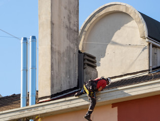 bricklayer performs maintenance of a facade of a building and cleaning flues