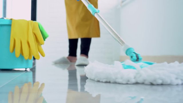 4k video of Woman housekeeper with mop and bucket with cleaning agents for cleaning floor at home, Floor care and cleaning services.