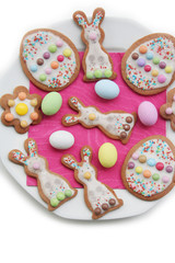 Fototapeta na wymiar Homemade Easter cookies in shape of bunny and Easter eggs on a plate on white background. Springtime background on selective focus 