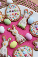 Fototapeta na wymiar Homemade Easter cookies in shape of bunny and Easter eggs on a plate on wooden table. Springtime background on selective focus