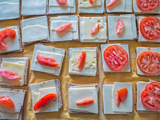 Close up overhead shot of cheese salad sandwiches being made ready for delivery to a food charity service run in Geneva, Switzerland.