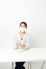 マスクをしながら手を消毒する女性