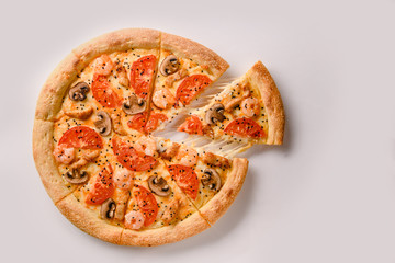 Pizza with shrimp and mushroom and slice with stretching cheese. Top view