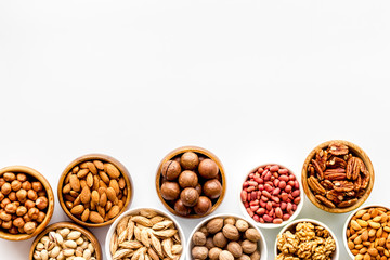 Set of macadamia, hazelnut, walnut, almond, pistachio, pecans nuts on white background top-down frame copy space