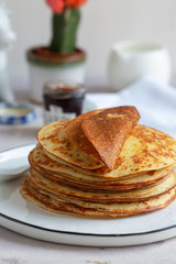 Fresh baked french crepes or Russians blinis on beautiful plate.