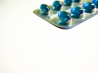 Medication in the form of a pack of blue pills on a gray background