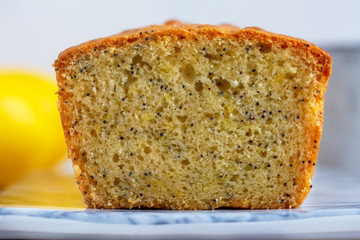 Lemon & Poppy Seed Pound Cake on marbled plate on grey table.