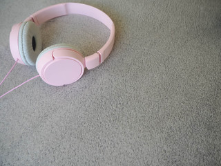 Fototapeta na wymiar Large pink headphones on a gray fur surface