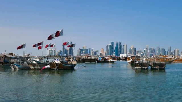 Traditional Dhow, Arab sailing vessels with Qatar flags in the harbour with the Doha skyline in the background