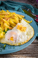 Fried egg served with boiled potatoes and yellow beans.