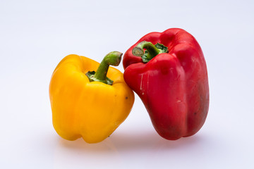 Red and yellow peppers isolated in front of a white background