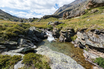 Fototapeta na wymiar Mountains and stream at Nivolet plateau in Gran Paradiso National Park. Aosta Valley, Italy