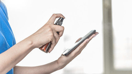 Woman Cleaning Smartphone screen with alcohol. Concept of Cleaning dirty screen Phone for disease Prevention from Bacteria. Corona virus spread prevention. Coronavirus hand sanitizer sanitiser.