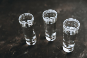 Tequila shots on the dark rustic background. Selective focus. Shallow depth of field.