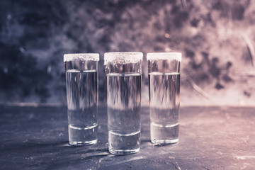 Tequila shots on the dark rustic background. Selective focus. Shallow depth of field.