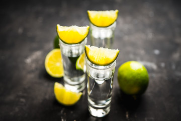 Tequila shots on the dark rustic background. Selective focus. Shallow depth of field.