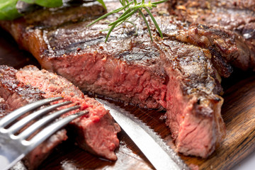grilled and sliced beef steak on wooden cutting board