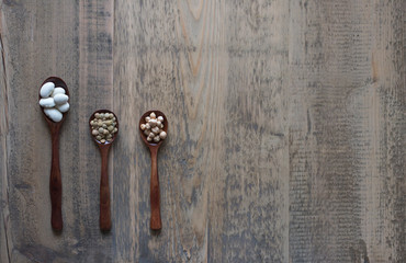 beans in broun spoons on a wooden rustic table