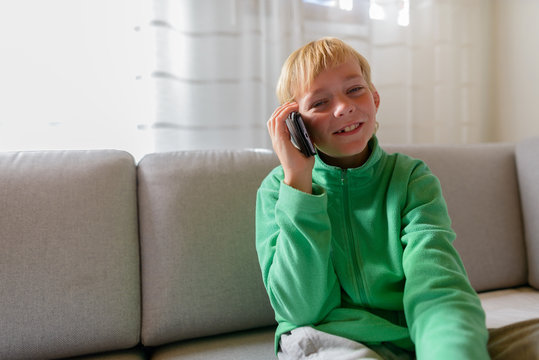 Happy Young Handsome Boy Talking On The Phone At Home