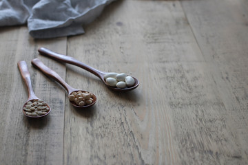 beans in broun spoons on a wooden rustic table