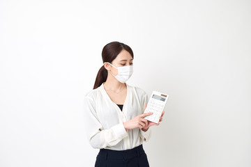 マスクをして電卓を持つ女性