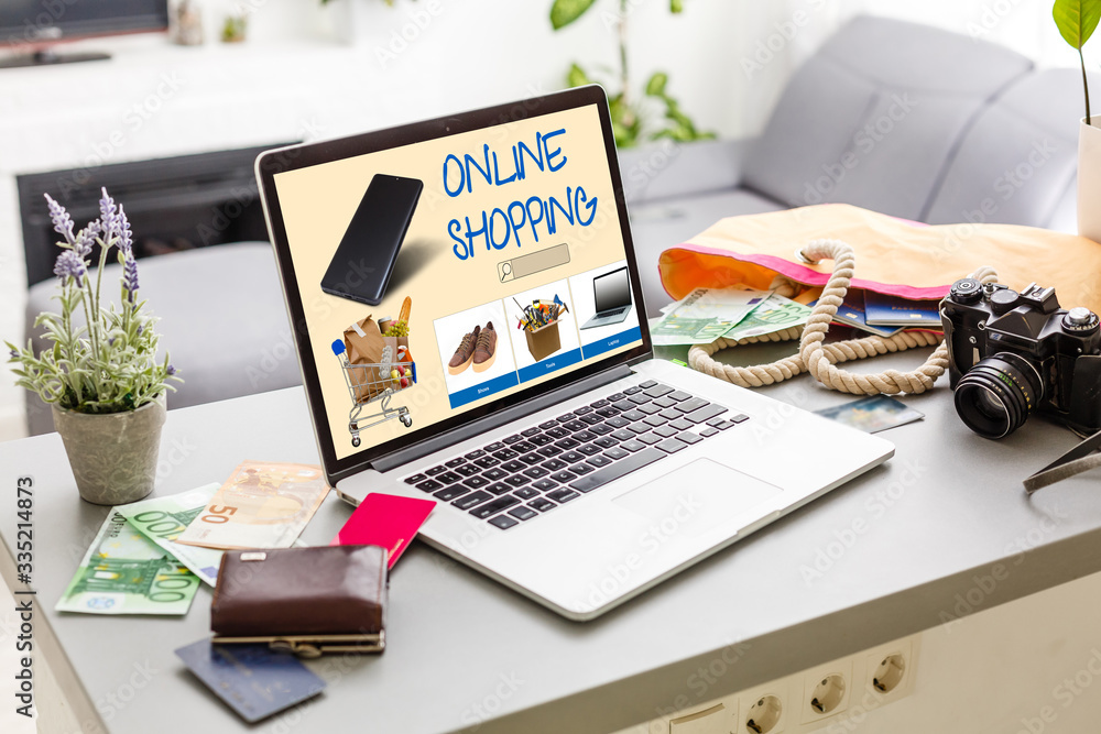 Poster laptop with onlain shopping site on the screen stands on the table in the office with phone and watc