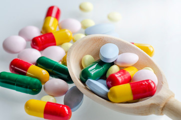 Wooden spoon with medicines on a gray background