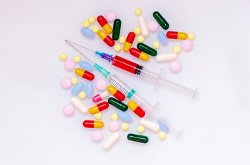Two syringes with different colored pills