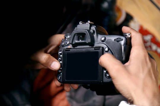 Man in suit taking photo. Photography concept.The photographer hold DSRL camera in his hands with shine white blur background indoors in studio or wedding store selective focus