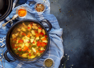 Cooking meat soup. A large blue pot with homemade chicken soup with turmeric and spices in bowls on a blue background. The concept of simple healthy food. Food photos, horizontal orientation, top view