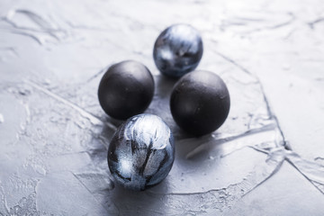 Holidays, design and modern easter concept - Black and brown easter eggs style minimalism on grey background.
