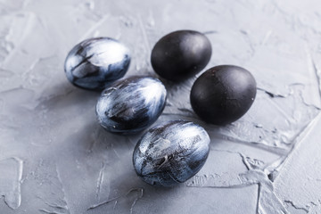 Holidays, design and modern easter concept - Black and brown easter eggs style minimalism on grey background.