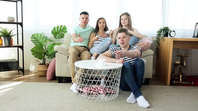 Fans watching the game. Group of young emotional people watching tv. Friends having fun together.