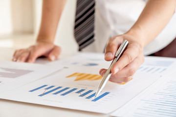 A business man is sitting at a desk and calculating financial graphs about real estate investment expenditures