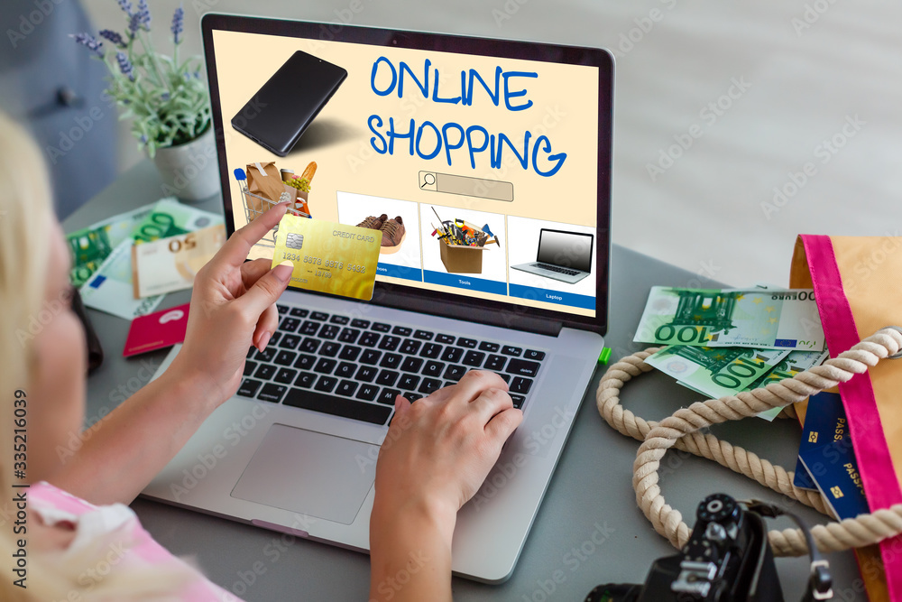 Poster laptop with onlain shopping site on the screen stands on the table in the office with phone and watc