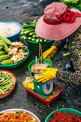 Vietnamese trader eating her breakfast on a scale at a Phu Quoc market